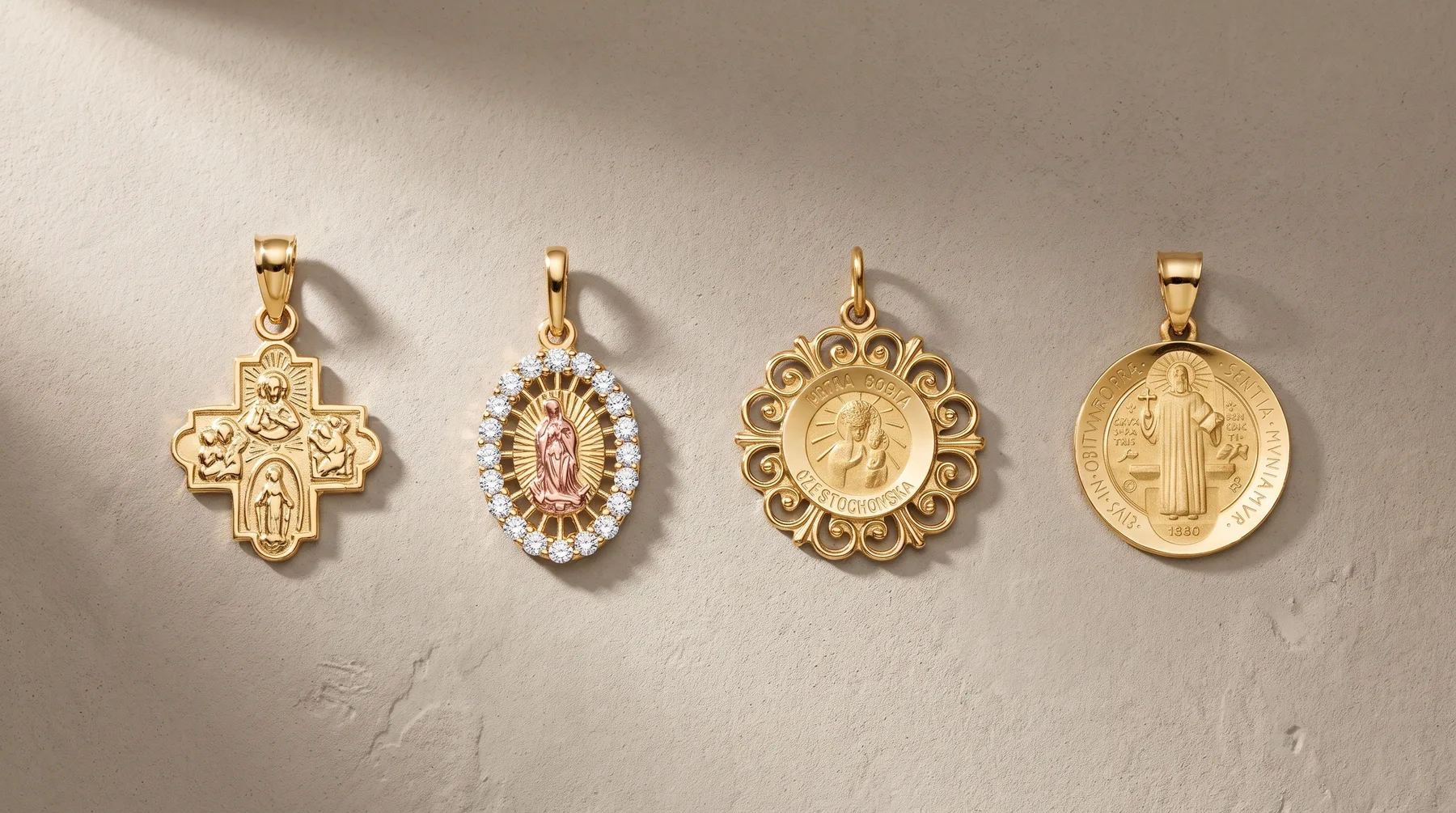 Four gold religious pendants displayed on a beige surface: a cross with four saints, an oval pendant with rhinestones and a figure, a circular pendant with ornate border and saint image, and a round medal with a figure and small hallmark.